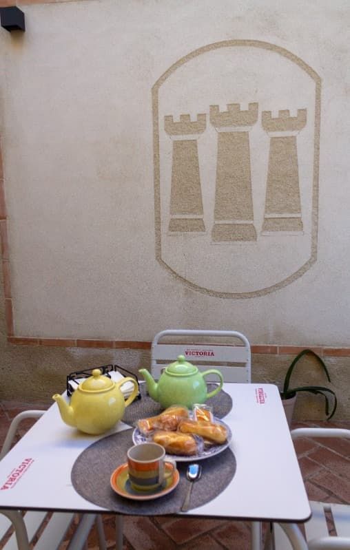 Un patio con plantas en macetas y una pizarra blanca en la pared.