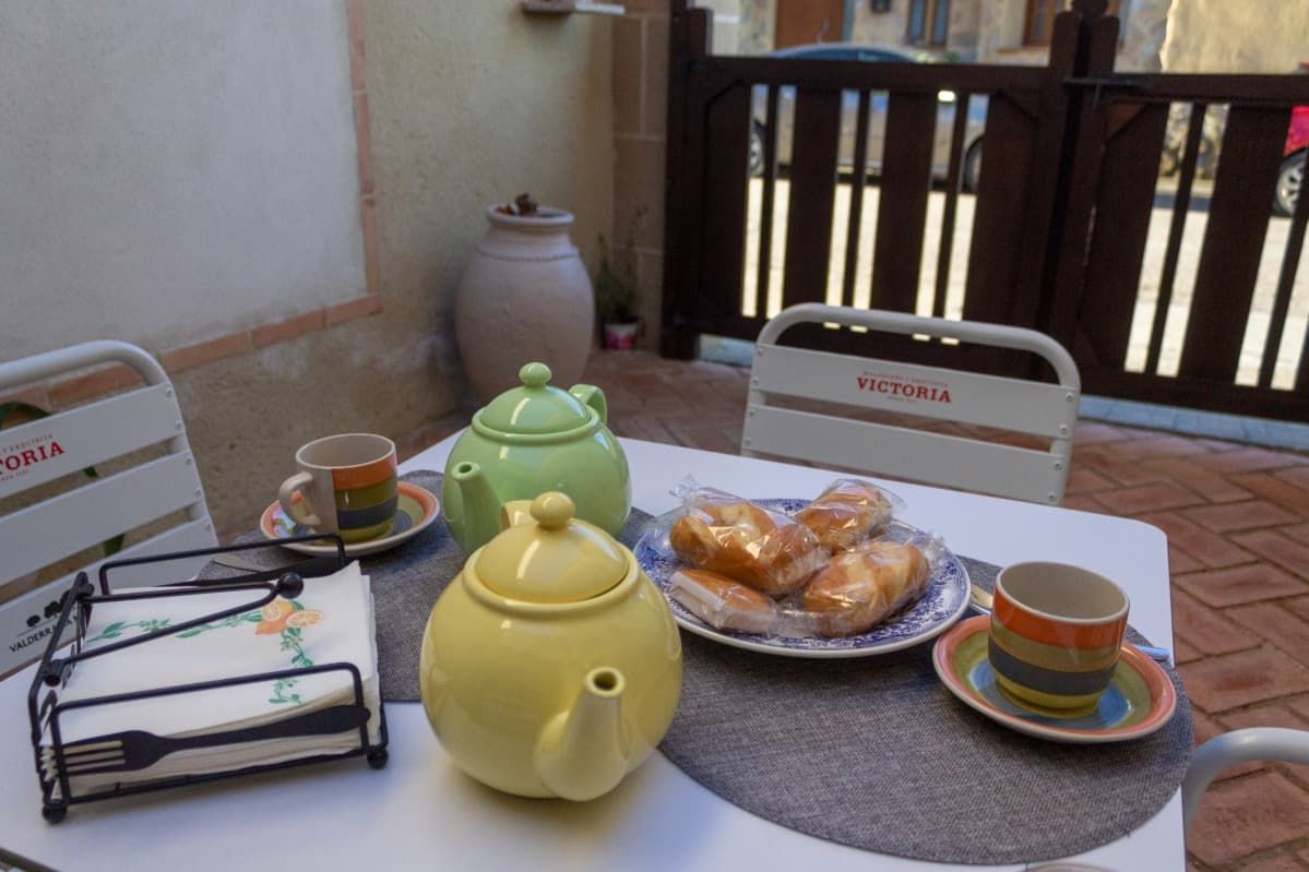 Una mesa con platos de comida y una tetera encima.
