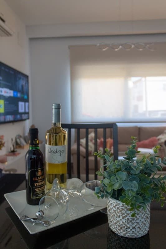 Una botella de vino está colocada en una bandeja sobre una mesa en una sala de estar.