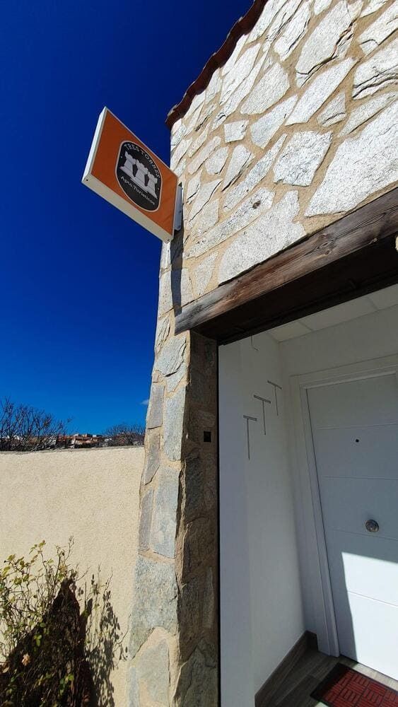 Un edificio de piedra con un cartel en el costado.