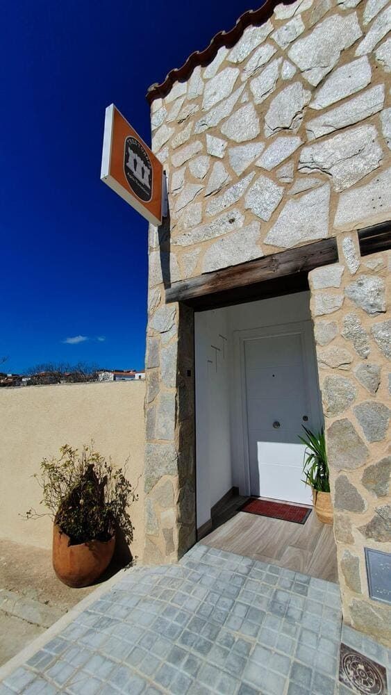 Un edificio de piedra con un cartel en el costado.
