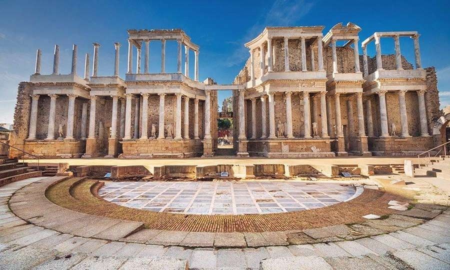 Un gran edificio con columnas y un área circular delante de él.