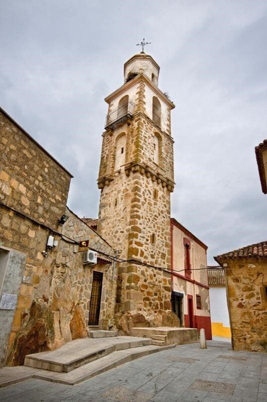 Una torre de piedra con una cruz en la cima