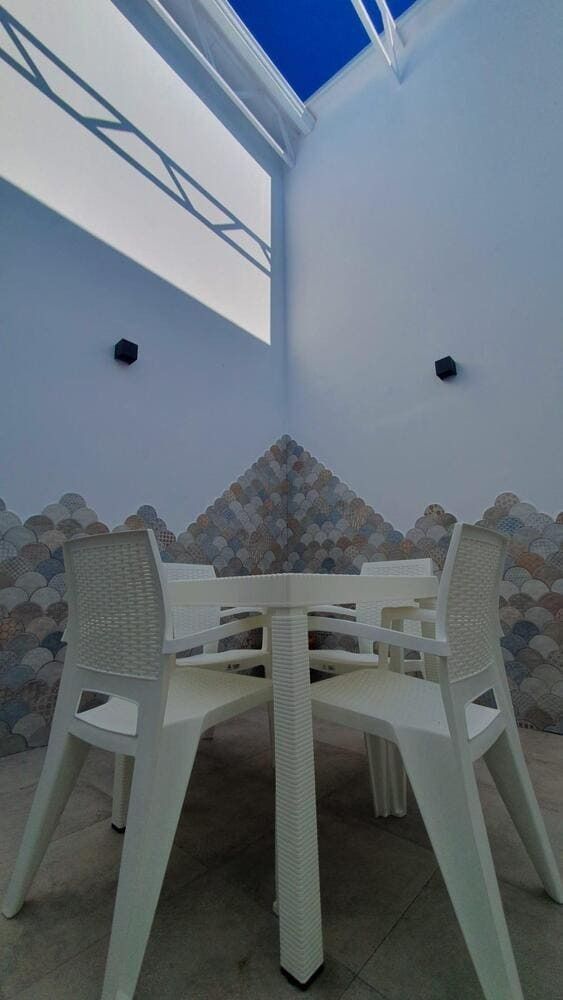 Una mesa y sillas en una habitación con un cielo azul de fondo.