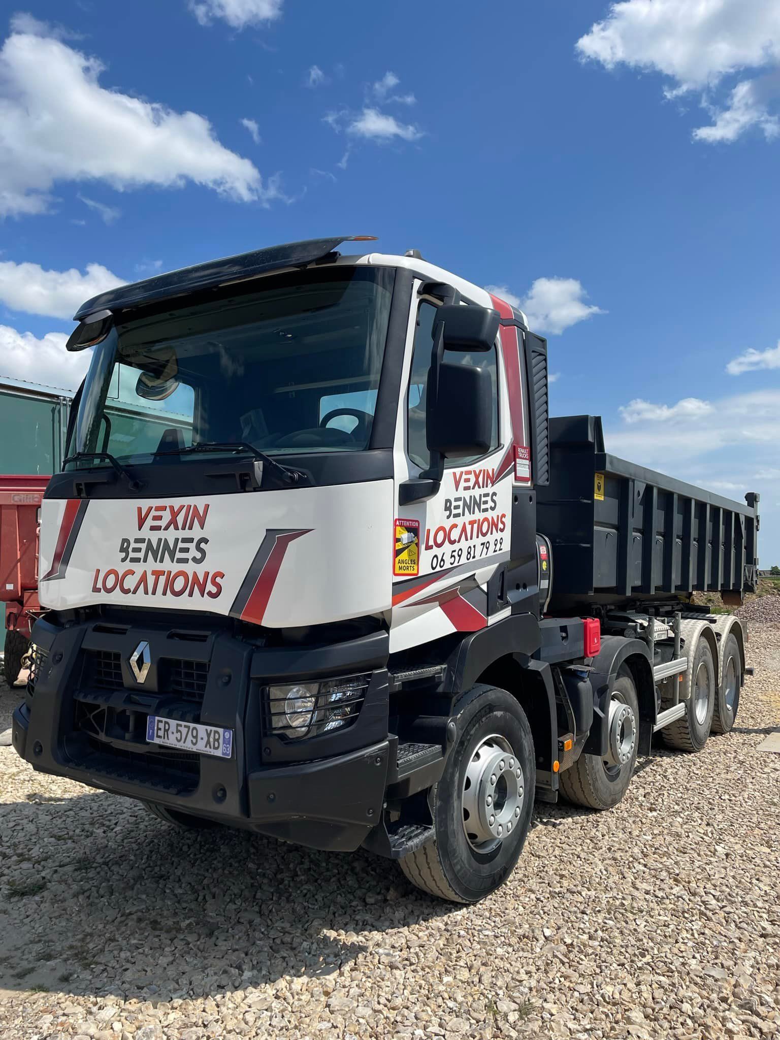 Chien noir et feu se reposant sur une couverture sur un siège de camion, la ceinture de sécurité rouge étant visible.