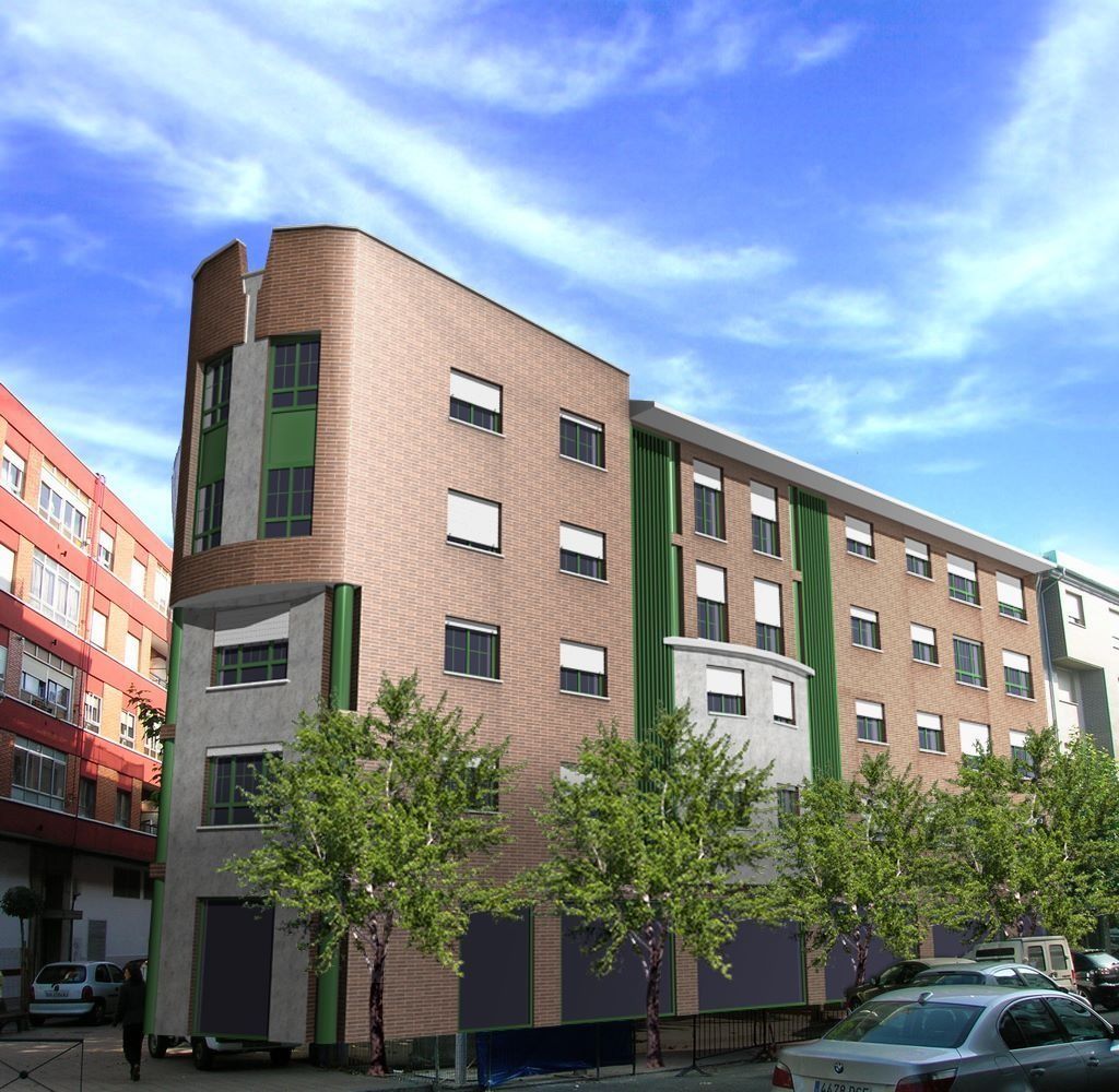 Un edificio con muchas ventanas y árboles delante.