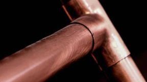 Un primer plano de un tubo de cobre sobre un fondo negro.