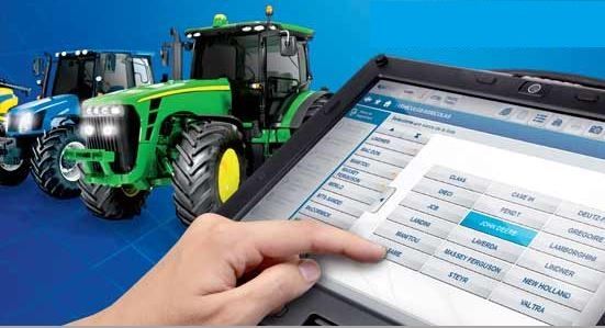 Una persona está usando una tableta con tractores en el fondo.