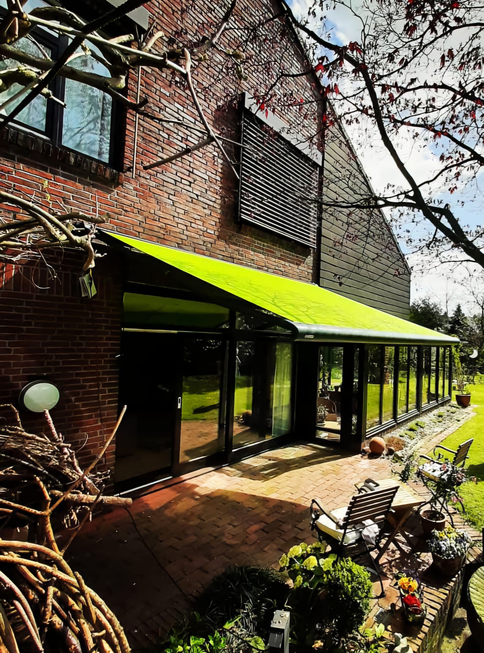 Ein Haus mit einer grünen Markise an der Seite