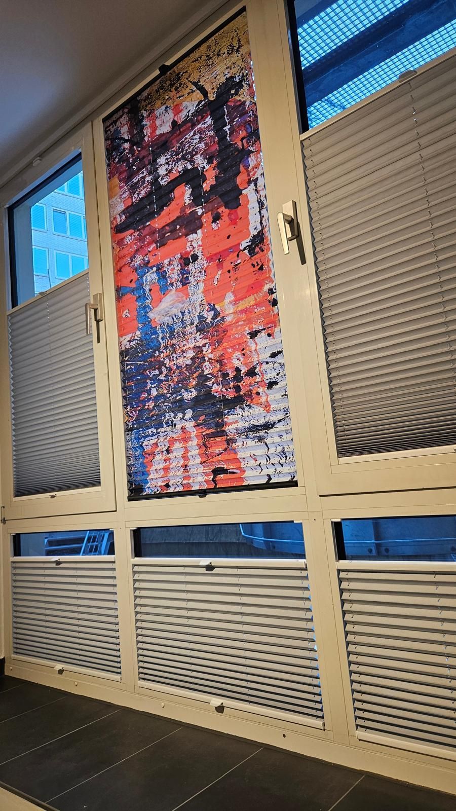 In einem Zimmer hängt ein Gemälde an einem Fenster.