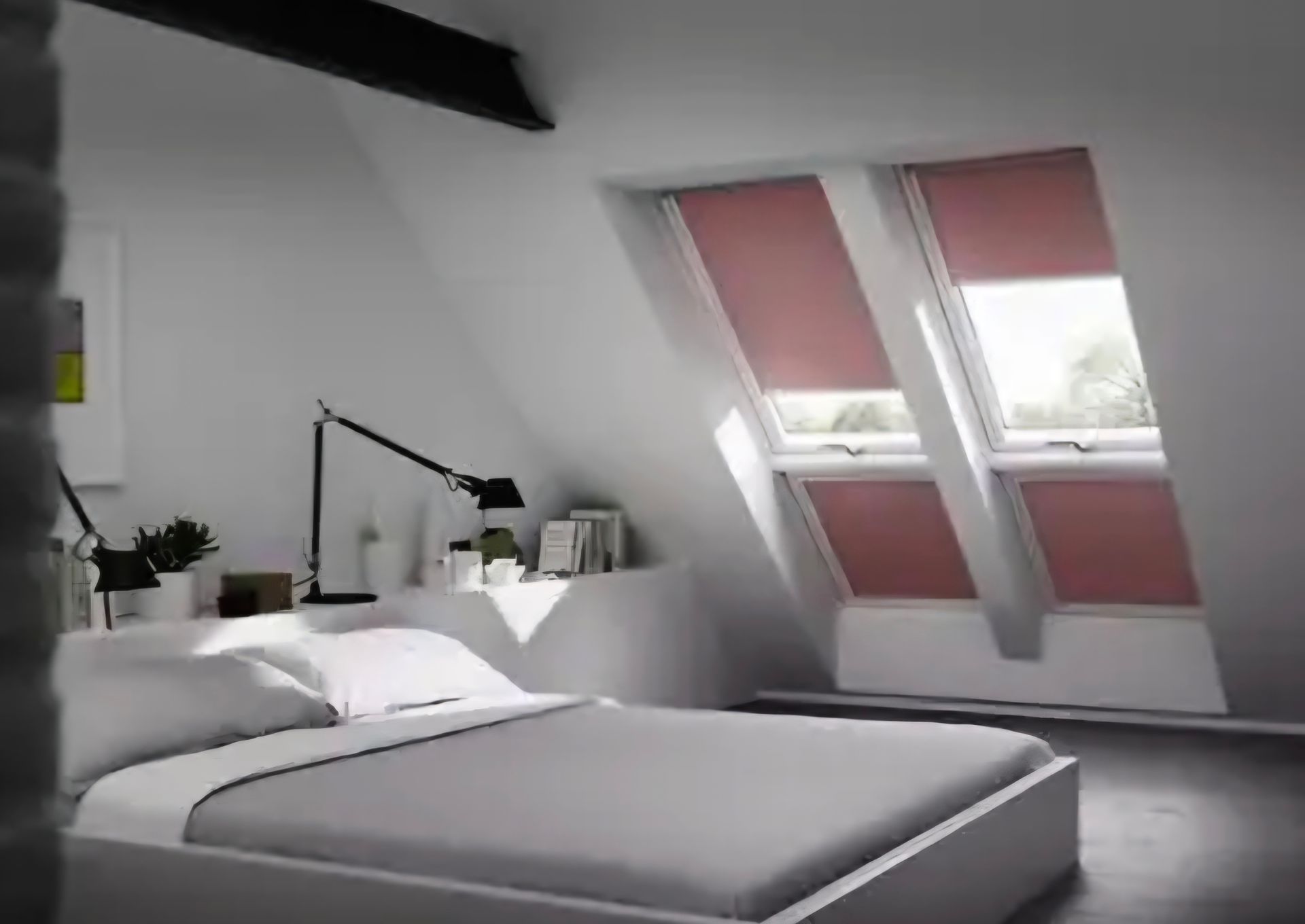 Ein Schlafzimmer mit einem Bett und zwei Fenstern mit roten Jalousien