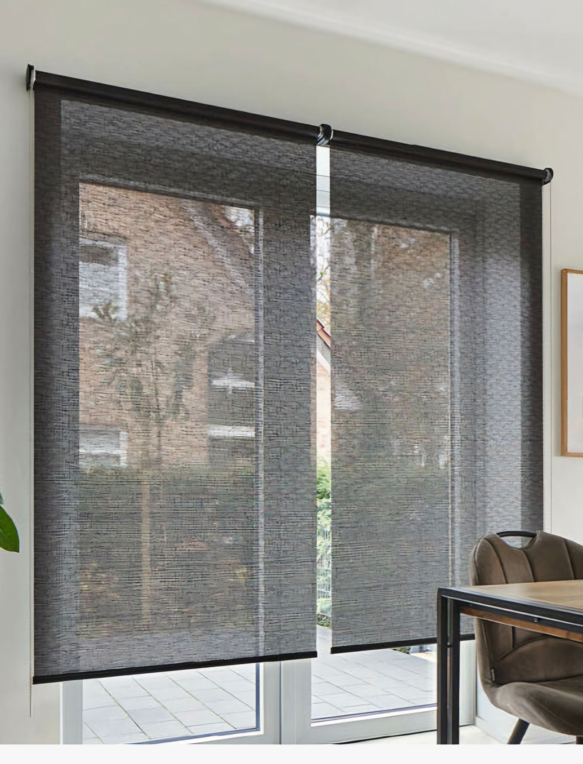 An einer Glasschiebetür hängen zwei Rollos.