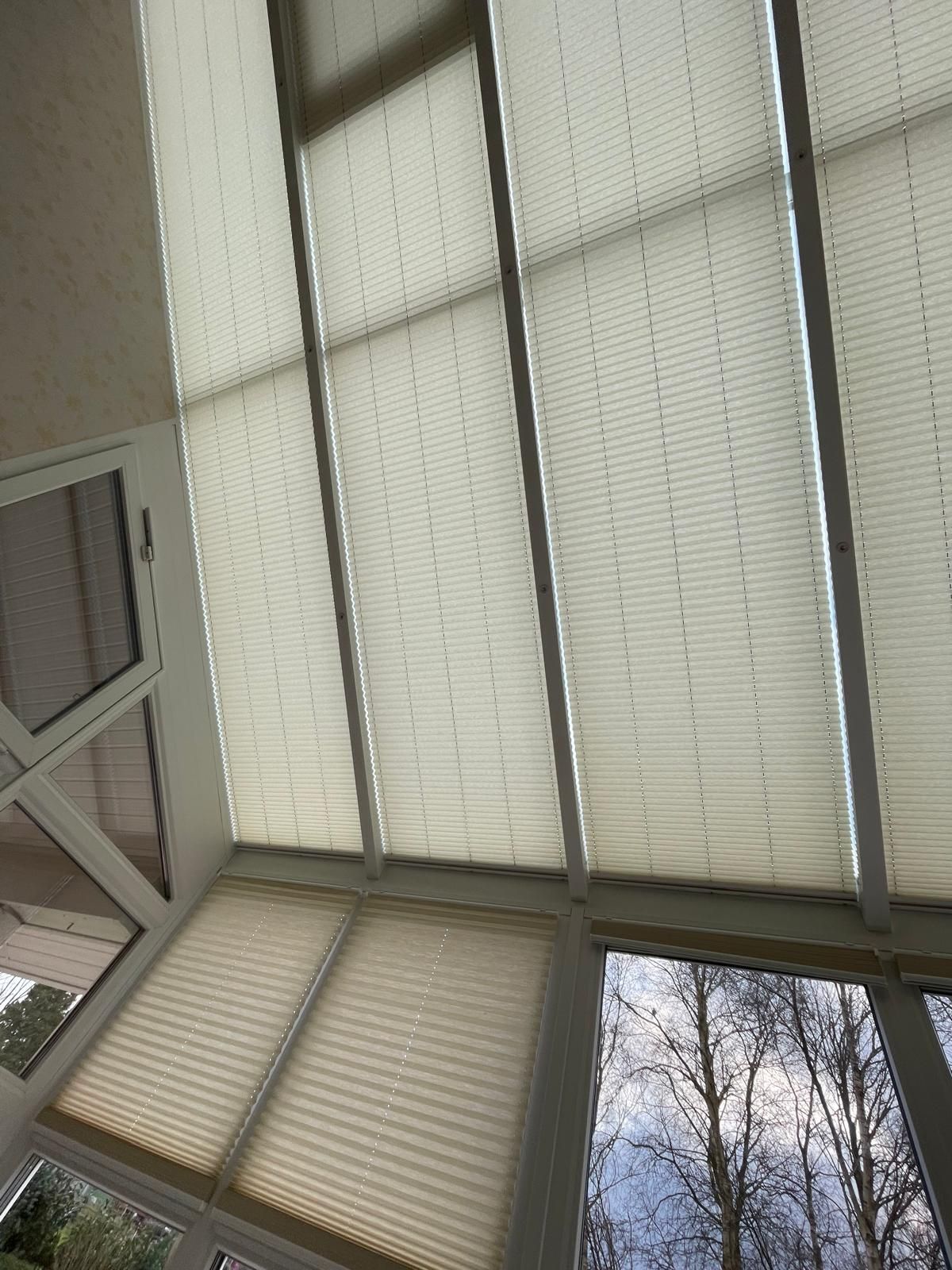 Ein Raum mit vielen Fenstern und Jalousien an der Decke.