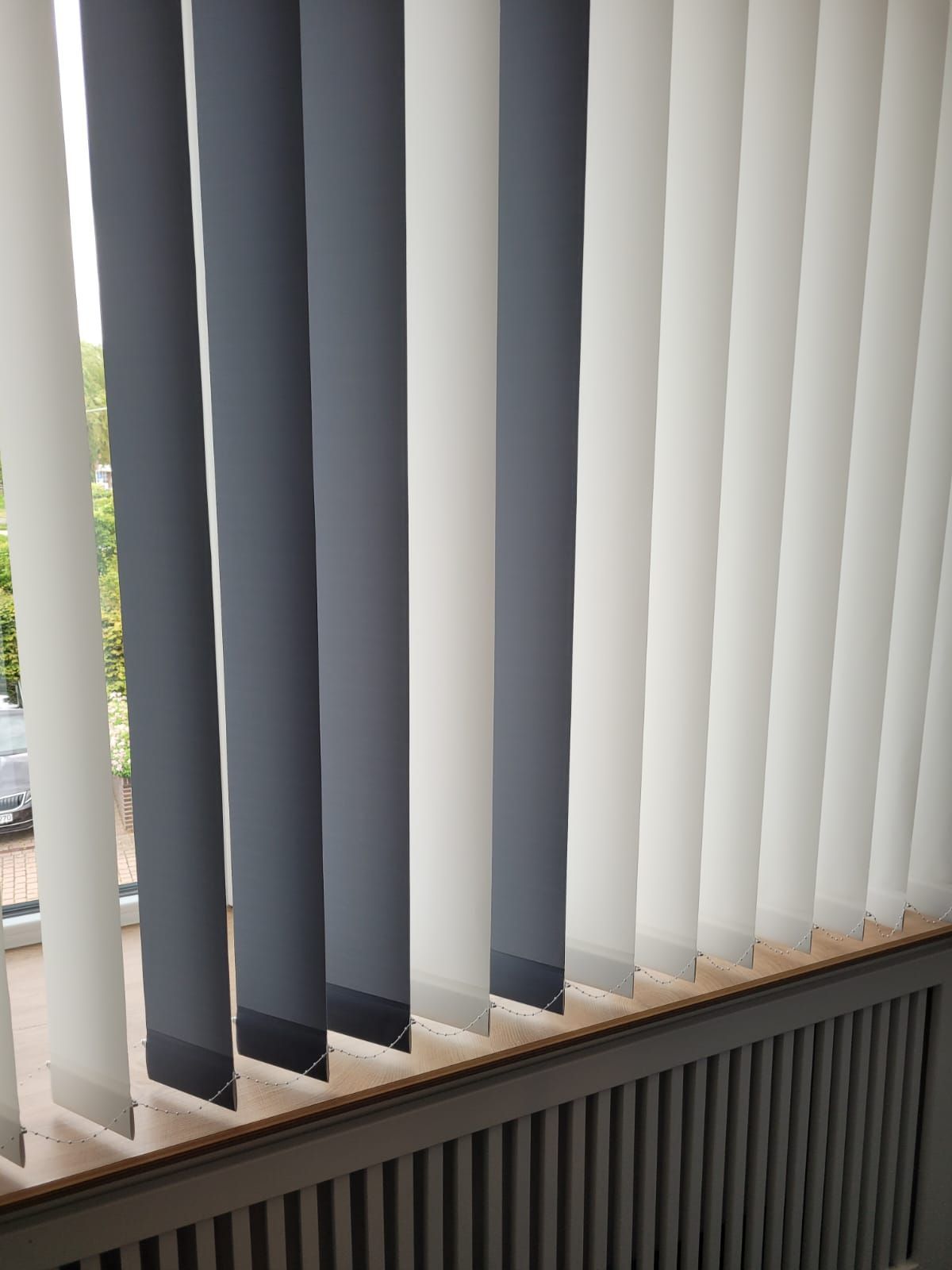 Eine Nahaufnahme eines Fensters mit vertikalen Jalousien.