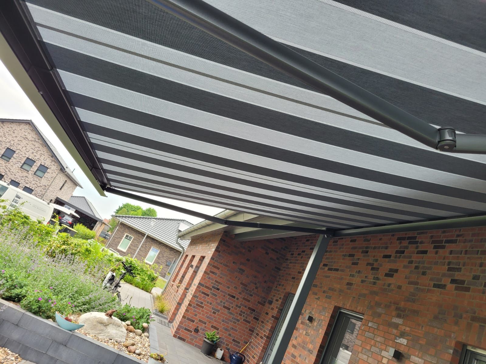 Eine schwarz-weiß gestreifte Markise hängt von der Decke eines Hauses.