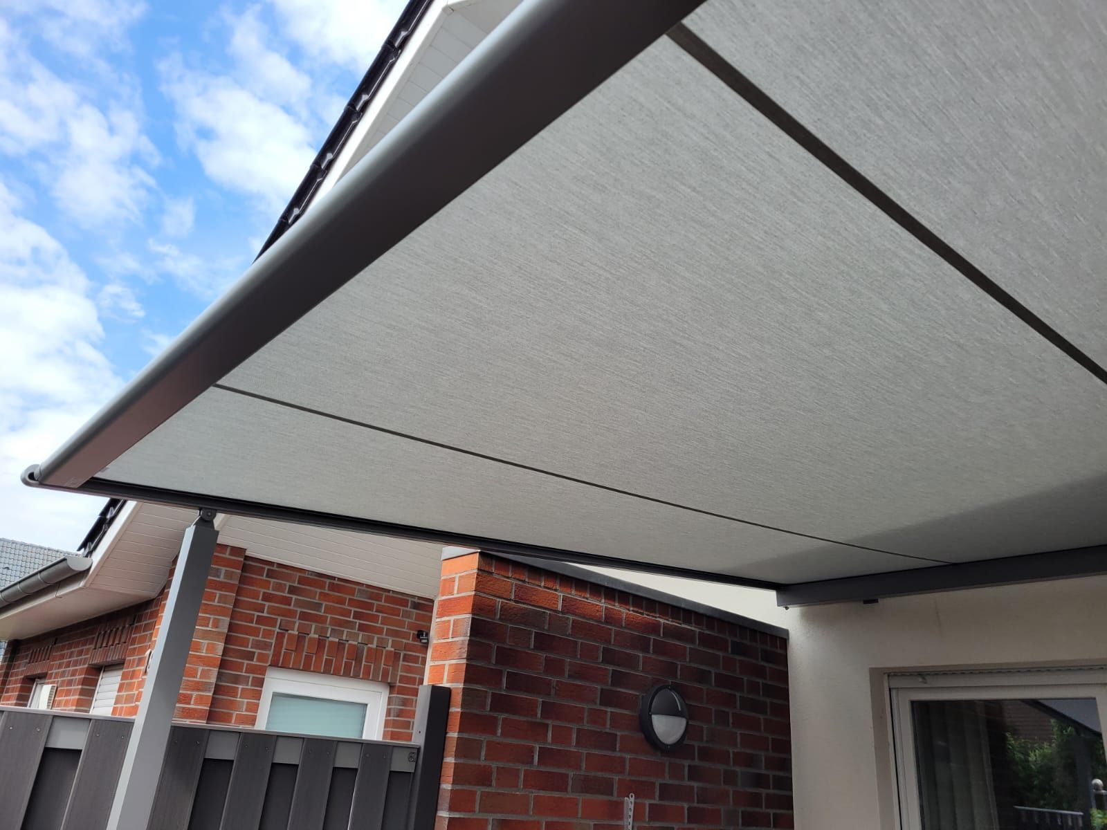 Eine weiße Markise befindet sich an der Seite eines Backsteingebäudes