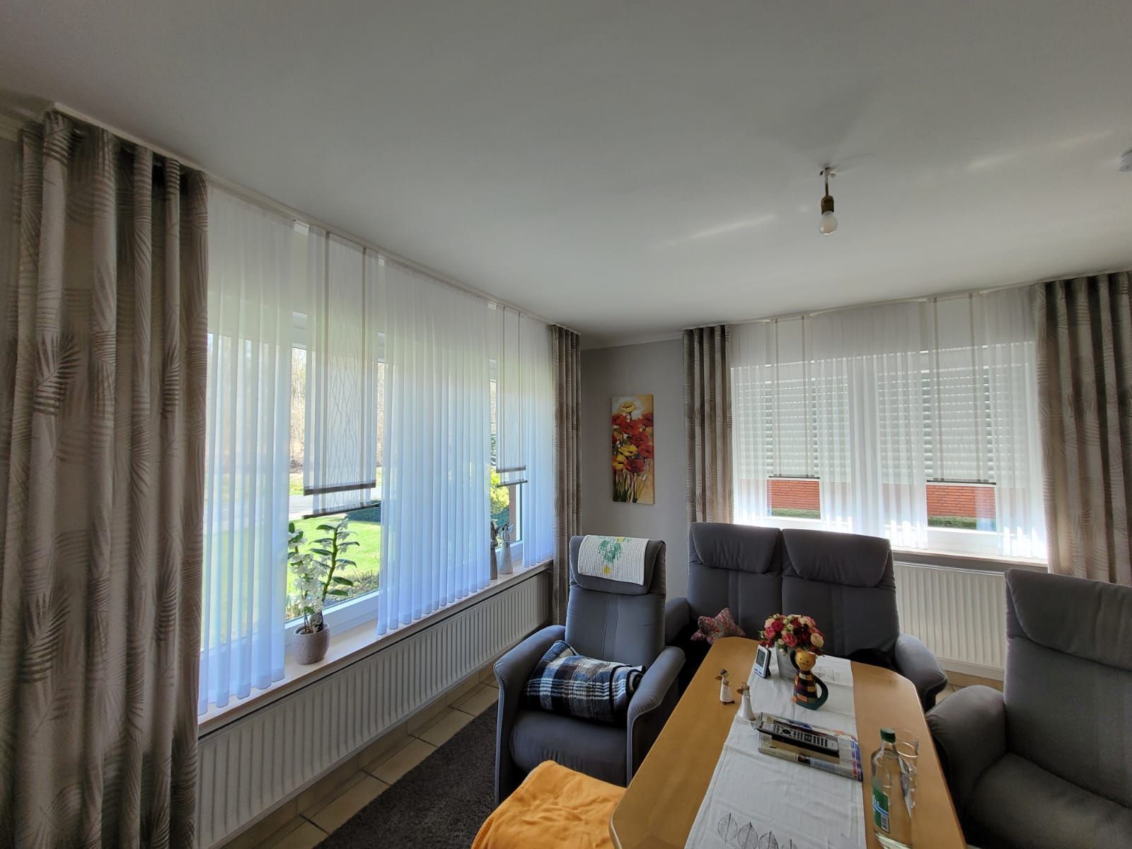 Ein Wohnzimmer mit Tisch, Stühlen und Vorhängen.