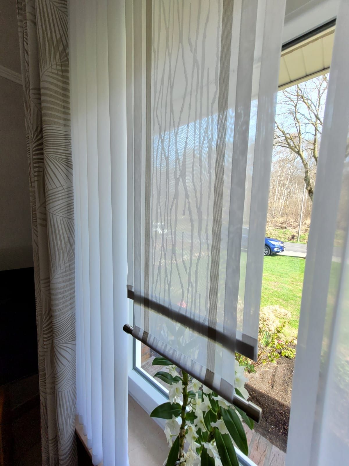 Ein Fenster mit weißen Vorhängen und einer Pflanze davor.