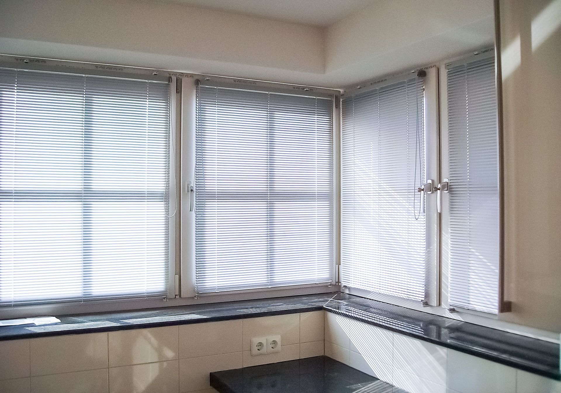 Eine Küche mit vielen Fenstern und Jalousien