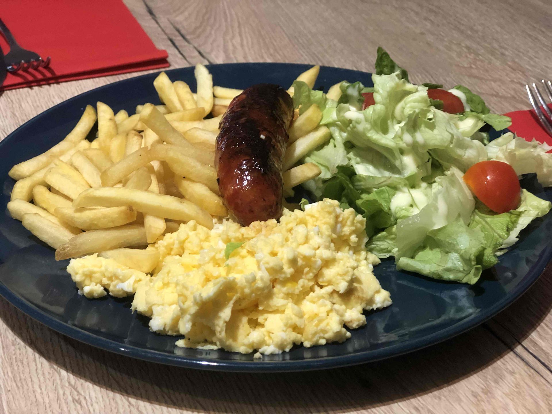 Saucisse, oeuf brouillé, frites et salade