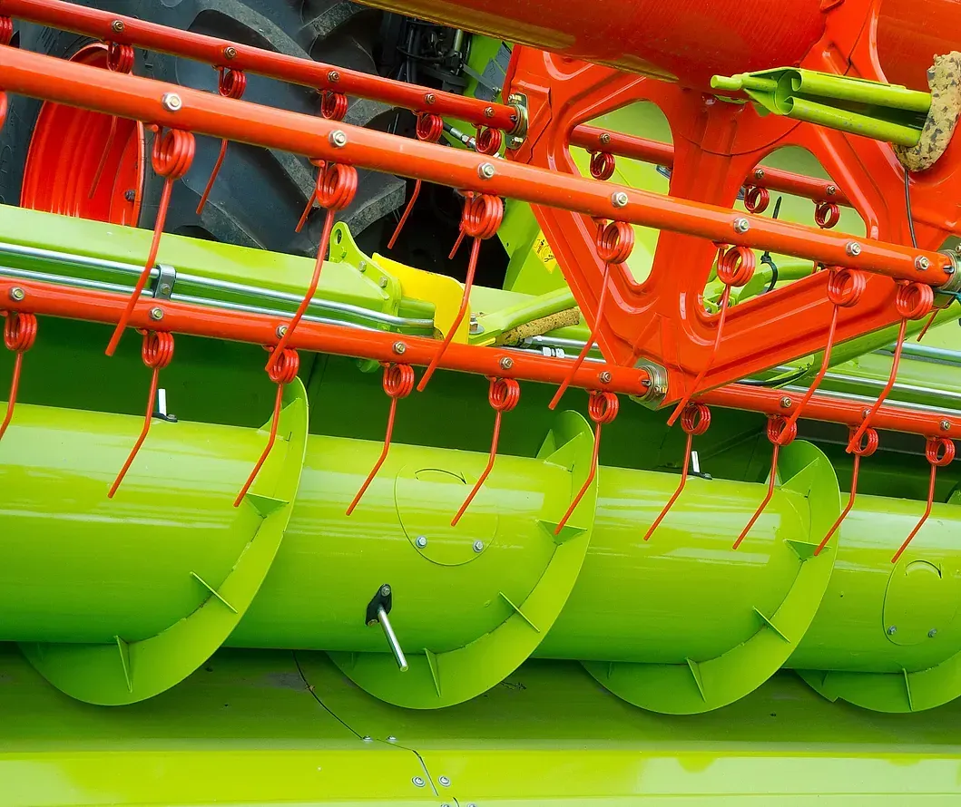 Un primer plano de una cosechadora verde y naranja.