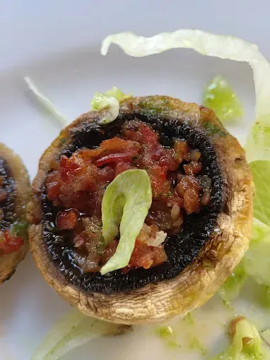 Un primer plano de un hongo con tomates y lechuga en un plato.