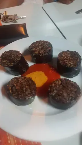 Un plato blanco cubierto con algunos trozos de comida y salsa.