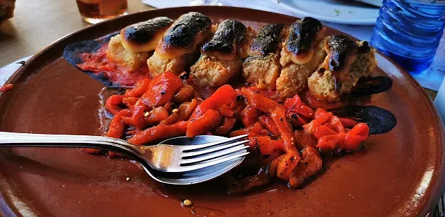 Un plato de comida con un tenedor y una cuchara encima.