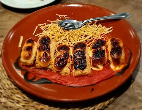 Un primer plano de un plato de comida con un tenedor sobre una mesa.