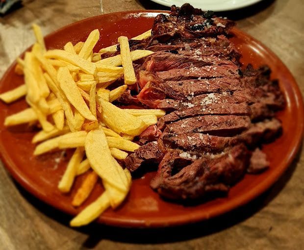 Un plato de bistec y papas fritas en una mesa