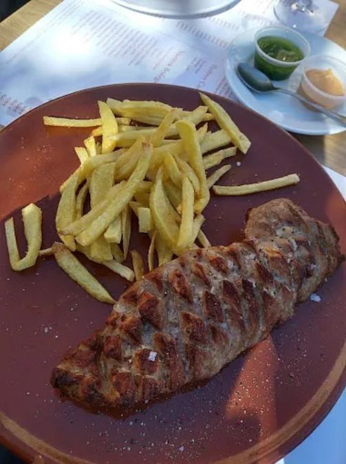 Un plato de carne y patatas fritas en una mesa