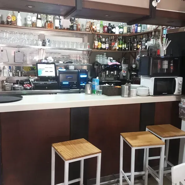 Una barra con taburetes de madera y un microondas.