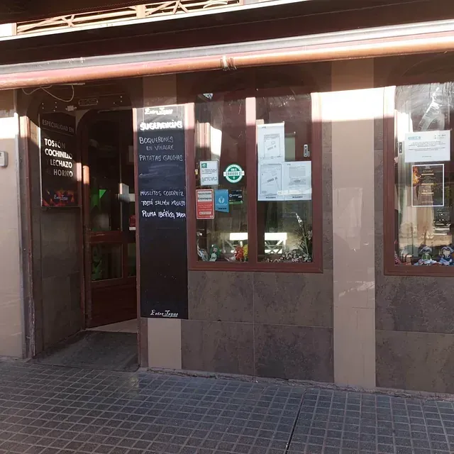 El frente de un restaurante con un menú en la pared.