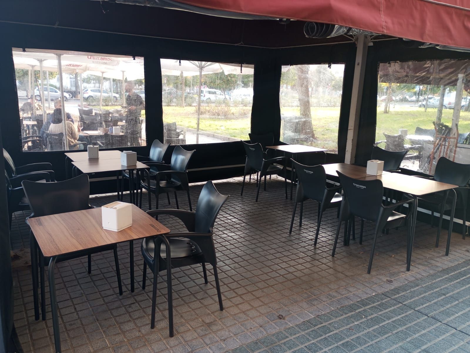 Un restaurante con mesas y sillas bajo un toldo.