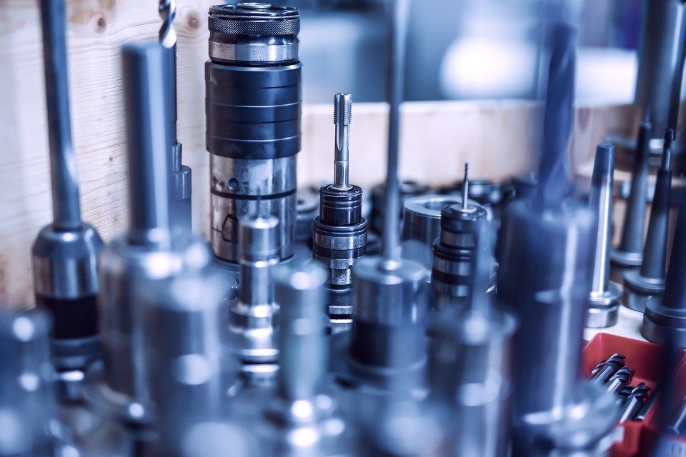 Oliver Günther GmbH, Mitarbeiter mit weißem Helm blickt zu anderem Mitarbeiter, eine Hand ist auf Boden aufgestützt, die andere hält einen Stift