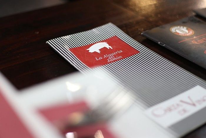Primer plano de tarjetas de visita sobre una mesa oscura, con una tarjeta roja con el logotipo de un oso blanco en el centro.