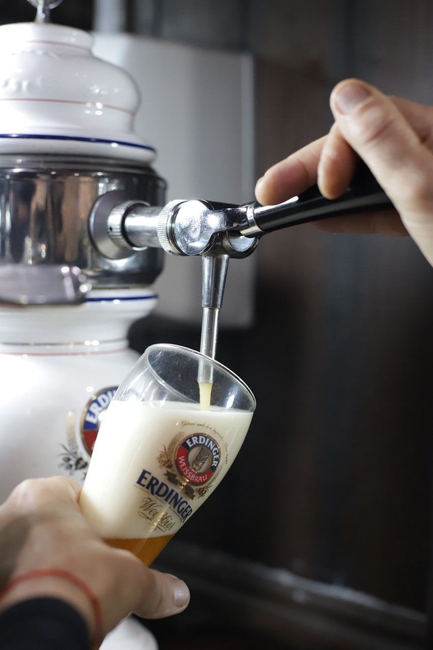 En un bar, se sirve cerveza de un grifo en un vaso con el logo de la marca.