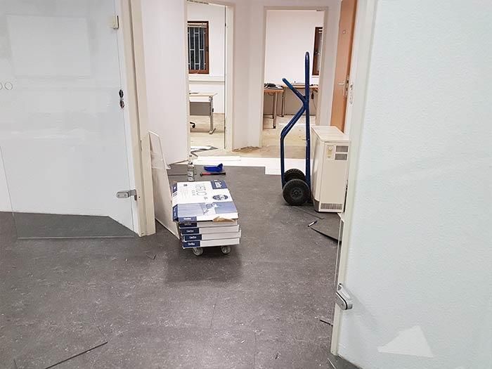 Ein Stapel Bücher liegt auf einem Wagen in einem Flur.