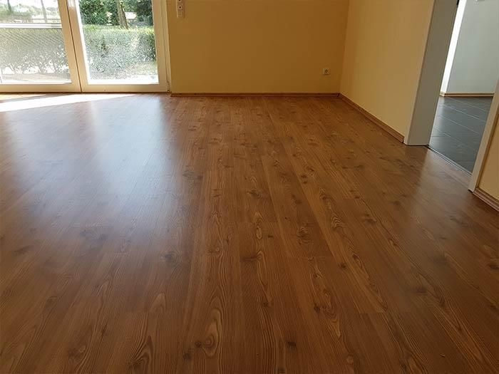 Ein Wohnzimmer mit Holzboden und Glasschiebetür.