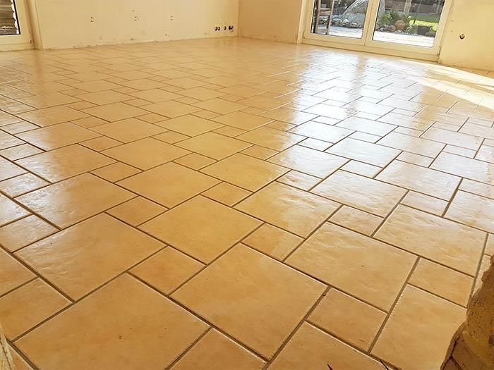 Ein Raum mit gefliestem Boden und einem Fenster.