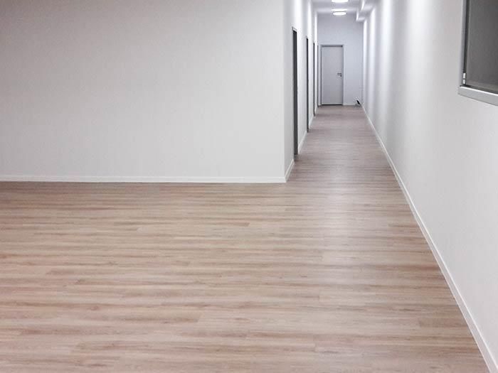 Ein langer Flur mit Holzboden und weißen Wänden
