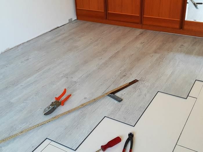 Ein Maßband liegt neben einer Zange auf dem Boden