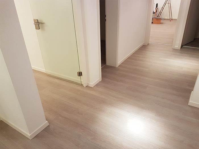 Ein Flur mit Holzboden und Glastür.