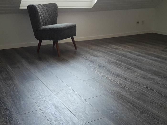 In einem Raum steht ein Stuhl auf einem Holzboden.