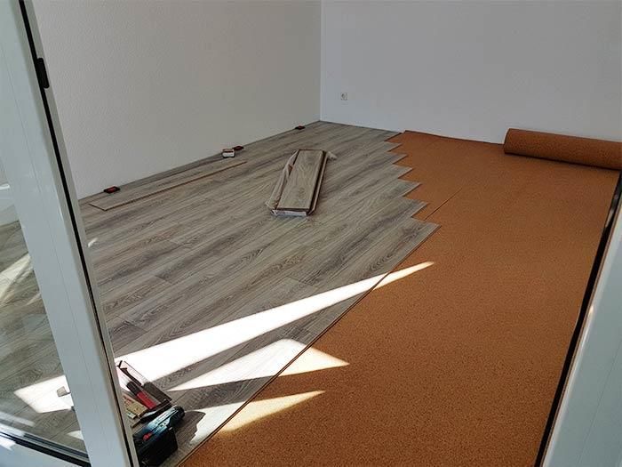 Ein Raum mit Holzboden und einer Rolle Korkboden.