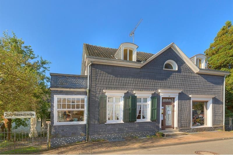 Ein großes Backsteingebäude mit grünen Fensterläden