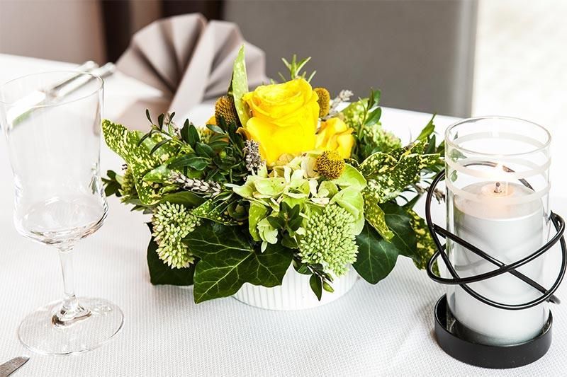 Ein Tisch mit Blumen und einer Kerze darauf