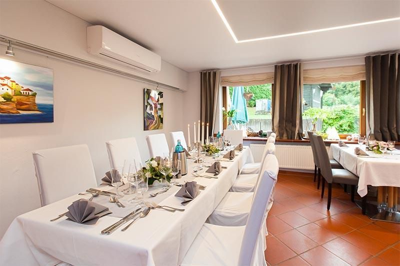 Ein Esszimmer mit einem langen Tisch und Stühlen