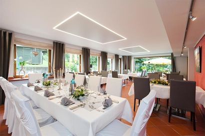 Ein großes Esszimmer mit Tischen und Stühlen für einen Hochzeitsempfang