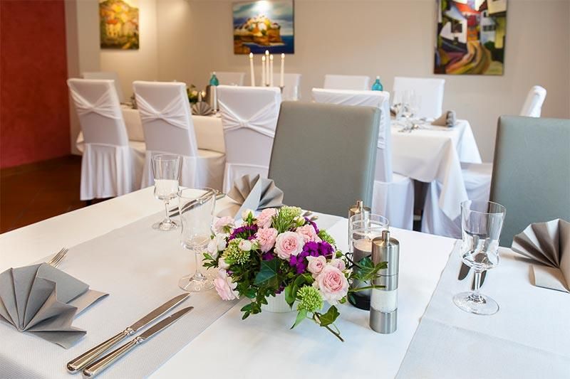 Ein Tisch in einem Restaurant mit einer Vase mit Blumen darauf